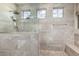Beautiful stone tile shower with rain shower head, pebble floor, glass door, and window at 69 E Benrich Dr, Gilbert, AZ 85295
