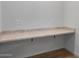 Close up of a built-in desk with counter in a neutral room with plenty of electrical outlets and hardwood style flooring at 6980 W Hedge Hog Pl, Peoria, AZ 85383