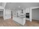 Open kitchen showcasing white cabinets, a granite island with sink, and stainless steel appliances at 6980 W Hedge Hog Pl, Peoria, AZ 85383
