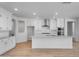 Elegant kitchen featuring white cabinets, stainless steel range hood, and spacious granite island at 6980 W Hedge Hog Pl, Peoria, AZ 85383