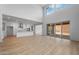 A bright living room with a kitchen and dinning room with large sliding glass doors and hardwood-style flooring at 6980 W Hedge Hog Pl, Peoria, AZ 85383