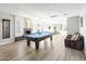 Bright, open living room featuring hardwood floors, a pool table, and a cozy seating area at 8201 E Piccadilly Rd, Scottsdale, AZ 85251
