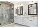 Modern bathroom featuring double sinks, white cabinetry, quartz countertop, a walk-in shower, and decorative mirrors at 937 W Glacier Dr, Chandler, AZ 85248