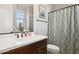 Well-lit bathroom featuring a vanity with modern fixtures and a decorative shower curtain at 937 W Glacier Dr, Chandler, AZ 85248