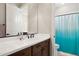 Modern bathroom with a sleek vanity, large mirror, and a shower with a bright aqua curtain at 937 W Glacier Dr, Chandler, AZ 85248