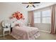 Charming bedroom featuring a beautiful flower wall decor, a ceiling fan, and plenty of natural light at 937 W Glacier Dr, Chandler, AZ 85248