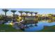 Scenic view of community lake, showcasing lush landscaping, waterfalls, and the community's entrance at 937 W Glacier Dr, Chandler, AZ 85248