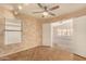 Cozy bedroom with wood-look floors, ceiling fan, ample natural light, and a connecting doorway at 9715 E Osage Ave, Mesa, AZ 85212