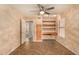 Comfortable bedroom with wood-look floors, custom shelves, built-in desk, ceiling fan, and ample natural light at 9715 E Osage Ave, Mesa, AZ 85212