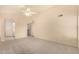 Bedroom boasting neutral carpeting, a ceiling fan, and access to the closet and bathroom at 9715 E Osage Ave, Mesa, AZ 85212