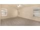 Spacious bedroom featuring neutral carpeting, a ceiling fan, and several windows for natural light at 9715 E Osage Ave, Mesa, AZ 85212