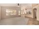 Bright living room with large windows, neutral paint, plush carpeting, and an open layout to the kitchen at 9715 E Osage Ave, Mesa, AZ 85212