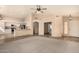 Open-concept living room featuring neutral tones, a ceiling fan, and seamless transition to the adjacent kitchen at 9715 E Osage Ave, Mesa, AZ 85212