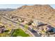 A high angle view of homes in a planned community nestled in the desert with mountain views in the distance at 10038 W Redbird Rd, Peoria, AZ 85383