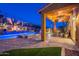 Stunning backyard featuring a swimming pool with cascading water features and a covered patio with comfortable seating at 10038 W Redbird Rd, Peoria, AZ 85383