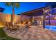 Backyard oasis featuring an outdoor kitchen, fire pit, covered seating, a pool, and elegant perimeter lighting at 10038 W Redbird Rd, Peoria, AZ 85383