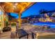 Serene backyard with a covered patio, a cozy fire pit, a built-in barbecue, and a stunning pool with water features at 10038 W Redbird Rd, Peoria, AZ 85383