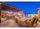 Inviting backyard featuring a fire pit, an outdoor kitchen, a pool with water features, and lush landscaping at 10038 W Redbird Rd, Peoria, AZ 85383