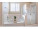 Relaxing bathroom featuring a soaking tub, a glass-enclosed shower, and plantation shutters at 10038 W Redbird Rd, Peoria, AZ 85383
