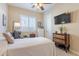 Bedroom featuring a ceiling fan, plantation shutters, and a mounted television at 10038 W Redbird Rd, Peoria, AZ 85383