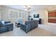 Carpeted living room with neutral walls, stylish furniture, ceiling fan, and built-in cabinets at 10038 W Redbird Rd, Peoria, AZ 85383