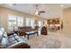 Open-concept living room featuring a ceiling fan, tile floors, and windows with plantation shutters at 10038 W Redbird Rd, Peoria, AZ 85383