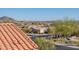 Scenic neighborhood view showcasing a terracotta tile roof, desert landscaping, and distant mountain views under a clear sky at 10038 W Redbird Rd, Peoria, AZ 85383