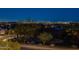 Expansive night view of the city lights from a residential area with mature trees and landscaping in the foreground at 10038 W Redbird Rd, Peoria, AZ 85383