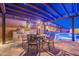 Outdoor dining area and kitchen with built in BBQ grill, fireplace and poolside view at 10038 W Redbird Rd, Peoria, AZ 85383