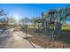 Neighborhood playground featuring a play structure, slide, and swing set with a sidewalk at 10038 W Redbird Rd, Peoria, AZ 85383