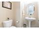 Powder room with pedestal sink, oval mirror, and decorative artwork at 10038 W Redbird Rd, Peoria, AZ 85383