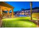 Backyard putting green with desert landscaping, ambient lighting, and an outdoor kitchen at 10038 W Redbird Rd, Peoria, AZ 85383