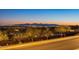 Scenic street view showcasing the city lights and mountain views in the distance at twilight at 10038 W Redbird Rd, Peoria, AZ 85383
