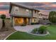 Inviting backyard with manicured landscaping, brick patio, covered area, and large windows offering ample natural light at 11544 W Ashby Dr, Peoria, AZ 85383