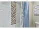 A tub and shower combination with white and mosaic tiled walls at 11544 W Ashby Dr, Peoria, AZ 85383
