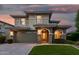 Elegant two-story home featuring a stone facade, arched entryway, and a spacious driveway at 11544 W Ashby Dr, Peoria, AZ 85383