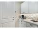 A bright kitchenette featuring white cabinets, mosaic backsplash, and a coffee station at 11544 W Ashby Dr, Peoria, AZ 85383