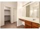 Bright bathroom with a sink, wood cabinets, a large mirror and a walk-in closet at 13001 W Bloomfield Rd, El Mirage, AZ 85335