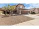 Two-story home with a brown garage door, neutral siding, and well-manicured landscaping at 13001 W Bloomfield Rd, El Mirage, AZ 85335