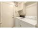 Functional laundry room featuring a side-by-side washer and dryer set, storage, and door at 13001 W Bloomfield Rd, El Mirage, AZ 85335