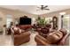 Spacious living room with leather furniture, ceiling fan, tile floors and lots of plants at 13001 W Bloomfield Rd, El Mirage, AZ 85335