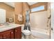 Bathroom featuring a shower-tub combo, cherry-wood vanity, and earth-tone walls for a warm, inviting feel at 13064 W Big Oak St, Peoria, AZ 85383