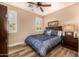 Comfortable bedroom with wood-look floors, ceiling fan, windows with shutters, and a queen bed with nice linens at 13064 W Big Oak St, Peoria, AZ 85383