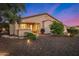 Exterior view of a stucco home with a covered patio, desert landscaping, and exterior lighting at 13064 W Big Oak St, Peoria, AZ 85383