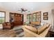 Bright living room featuring a leather sectional sofa, built-in shelving, and plantation shutters at 13064 W Big Oak St, Peoria, AZ 85383