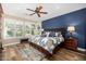 A serene bedroom features wood floors, a navy accent wall, plantation shutters, and a large window at 13064 W Big Oak St, Peoria, AZ 85383