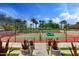 Well maintained tennis court with lush landscaping and shade trees on a sunny day in this luxurious community at 13064 W Big Oak St, Peoria, AZ 85383