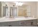 Bathroom showcasing a double vanity with marble countertop and modern faucets, complemented by an oversized mirror at 13275 W Bolero Dr, Sun City West, AZ 85375