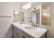 Bright bathroom featuring a double vanity with sleek fixtures and a large mirror, enhanced by modern lighting at 13275 W Bolero Dr, Sun City West, AZ 85375