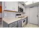 Kitchen featuring sleek white cabinets, modern appliances, and tile backsplash at 13275 W Bolero Dr, Sun City West, AZ 85375